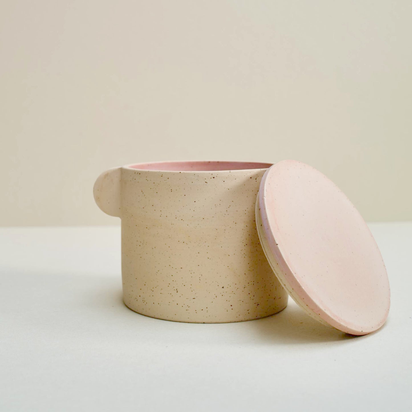 Speckled storage jar with a pink lid