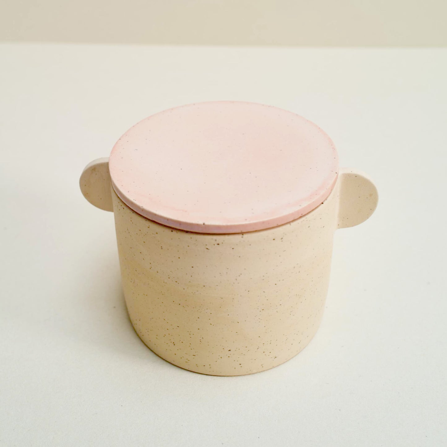 Speckled storage jar with a pink lid